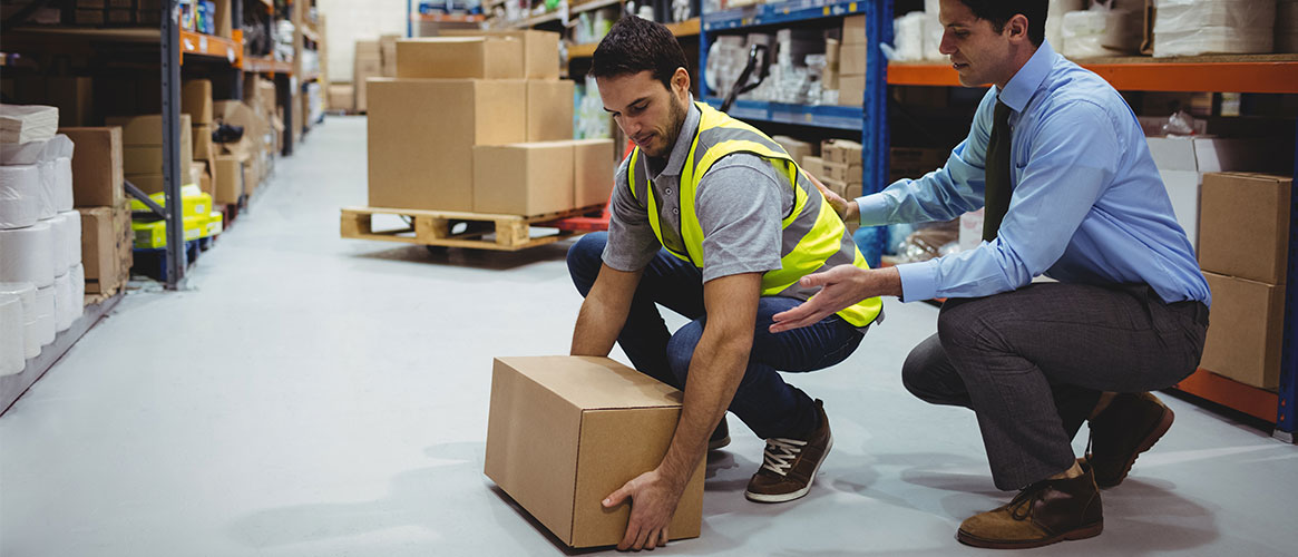Warehouse worker receiving instruction on how to properly lift.