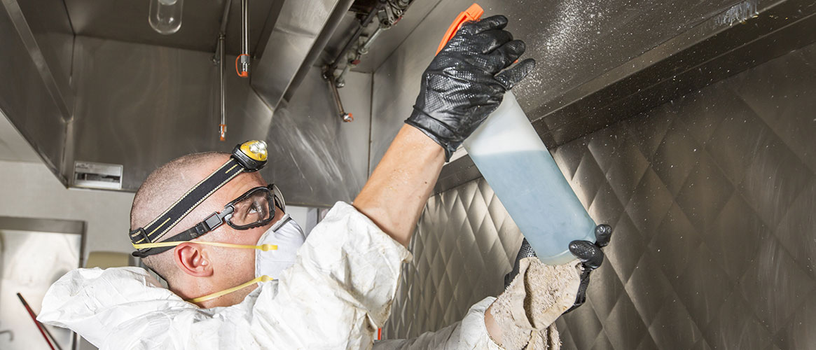 Worker using a solvent to clean equipment at his workplace.