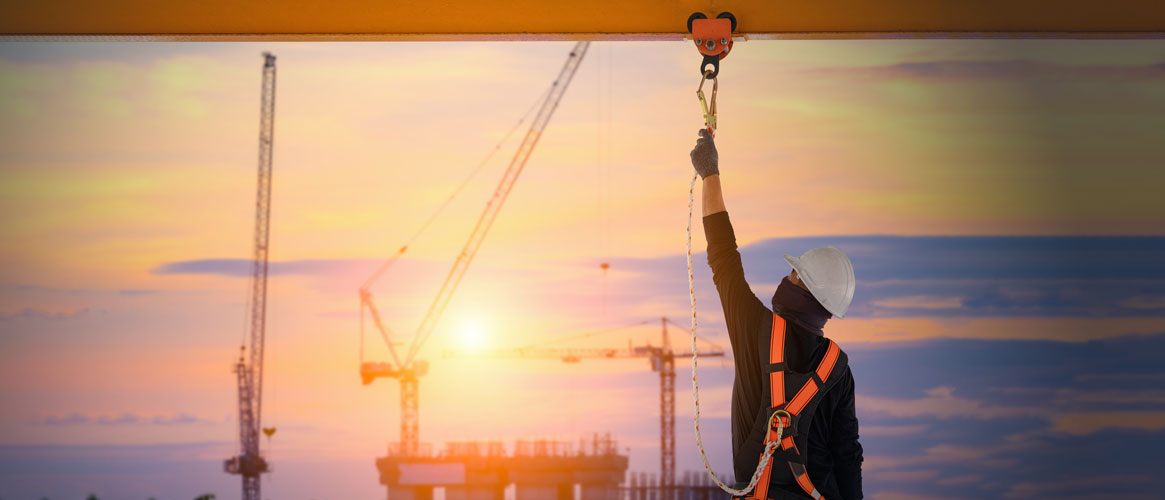 Construction worker connecting to fall protection