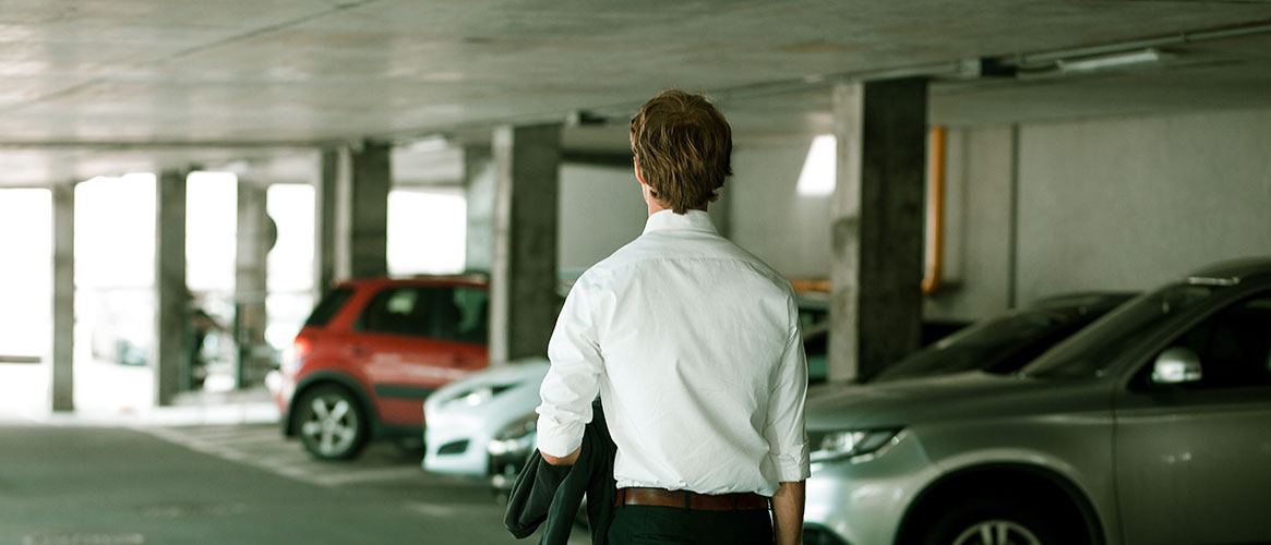 Person walking through a parking lot after arriving for work.