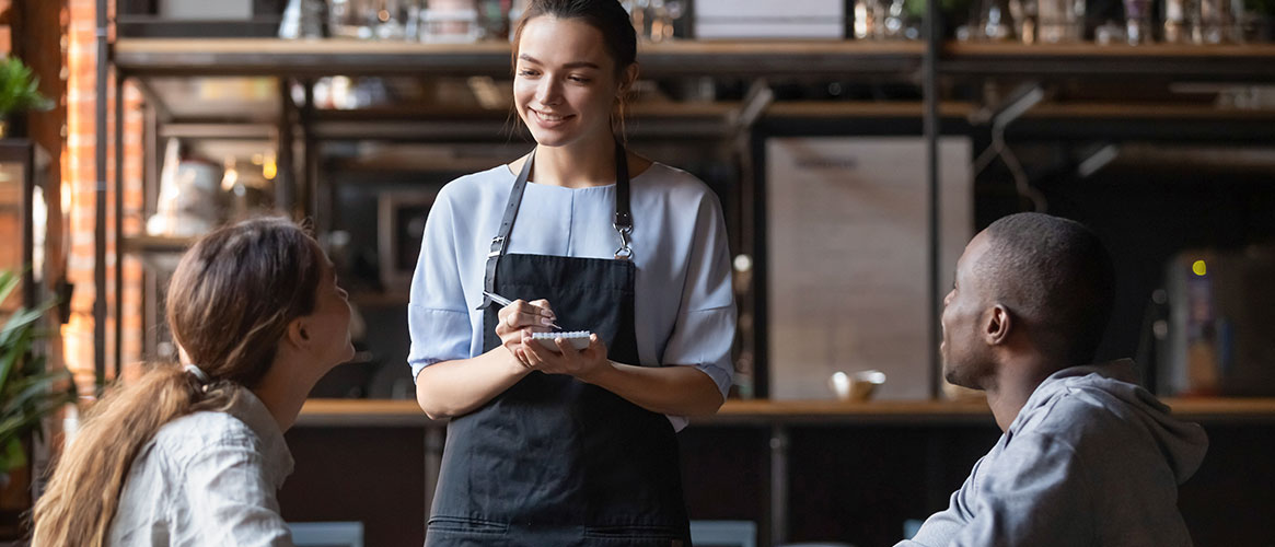 Restaurant employee greeting customers and taking their order