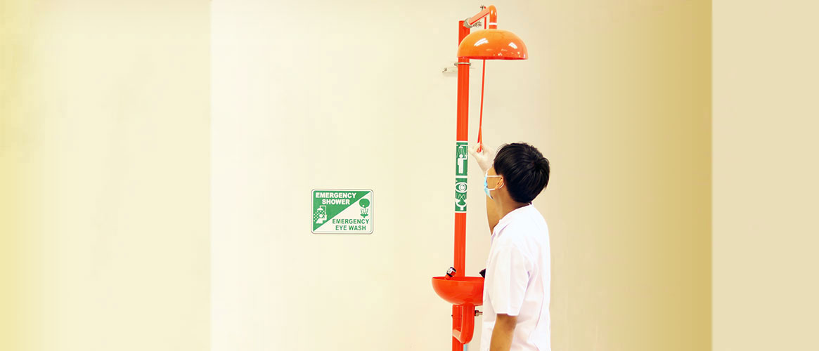 Worker about to test the combined eyewash/emergency shower equipment as part of his job.