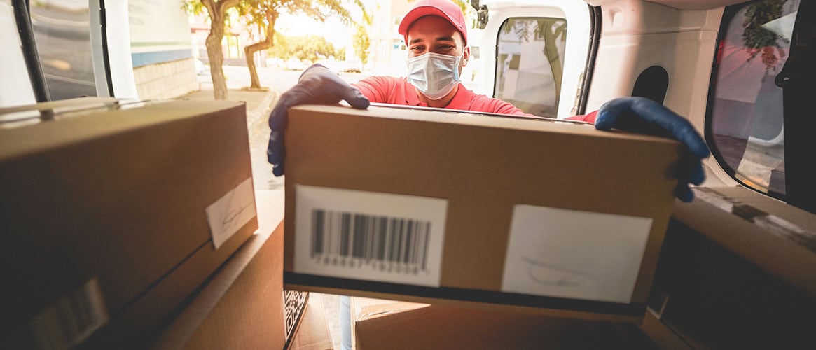 Delivery driver standing up straight, protecting his back, while unloading the delivery van