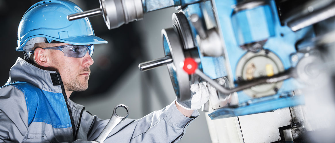 Machinist using Lock Out and Tag Out safety procedures on blue industrial machine