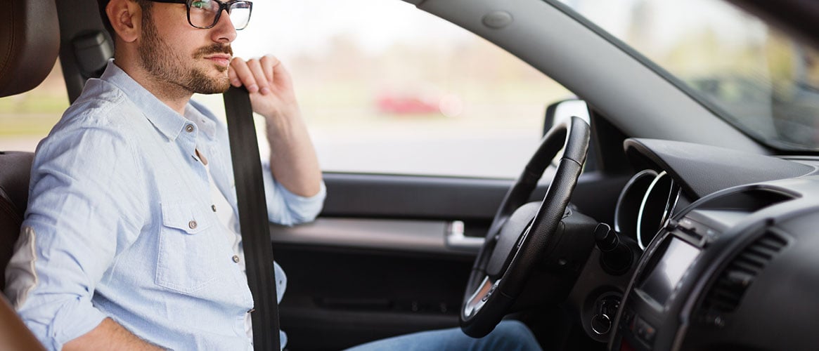 man putting on seat belt